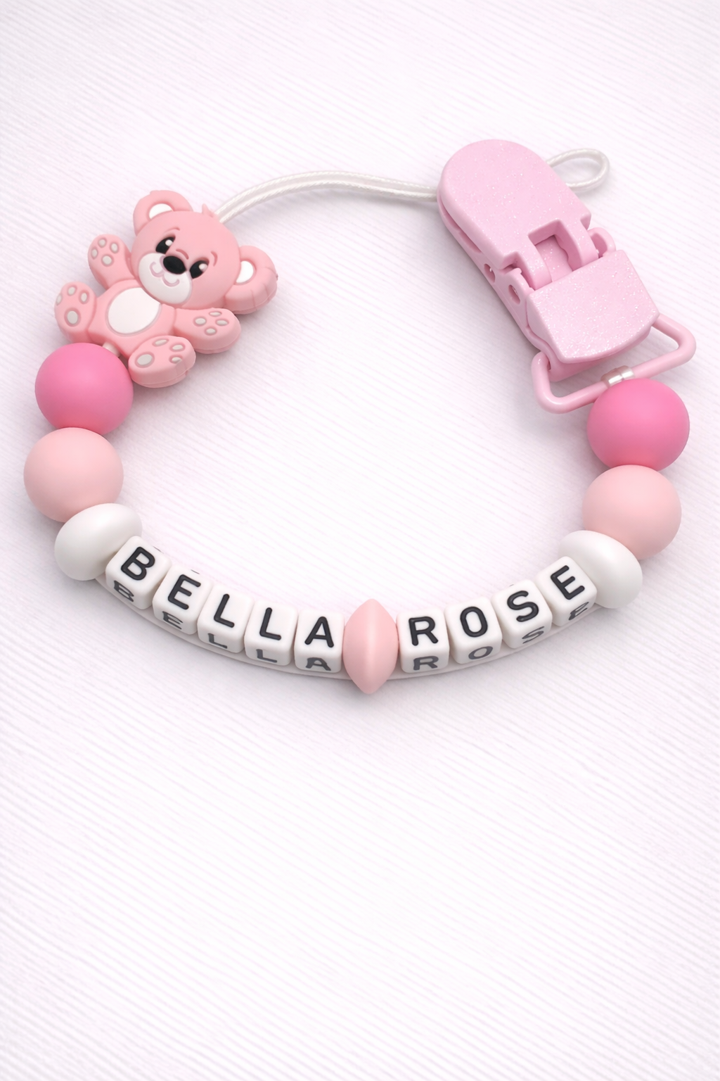Pink baby dummy clip with 'Bella Rose' on a white background