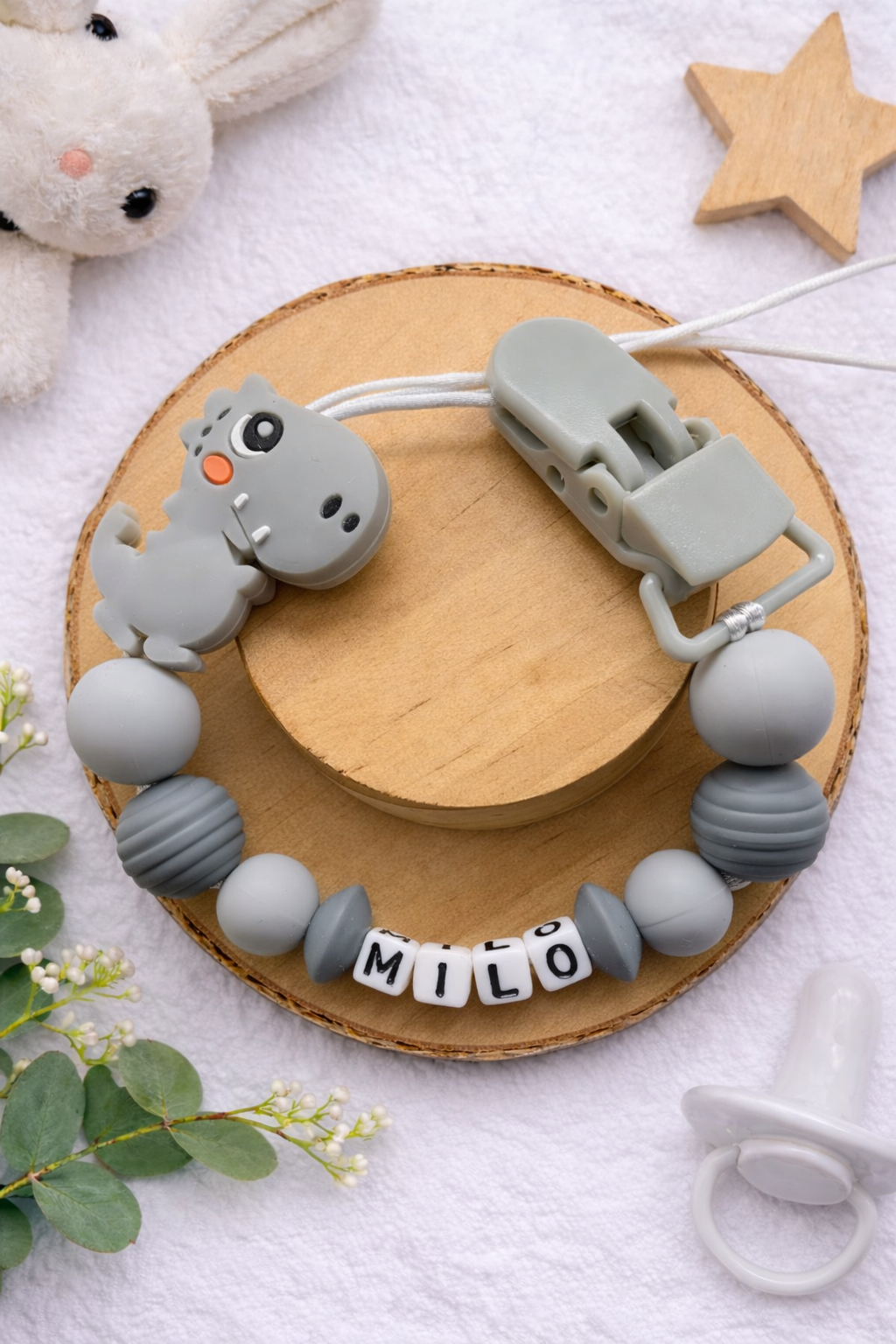 Dark grey personalised dummy clip featuring a dinosaur design for babies.