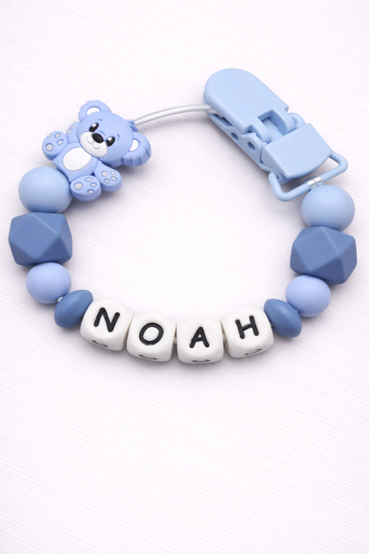 Blue baby teether with 'NOAH' beads on a white background