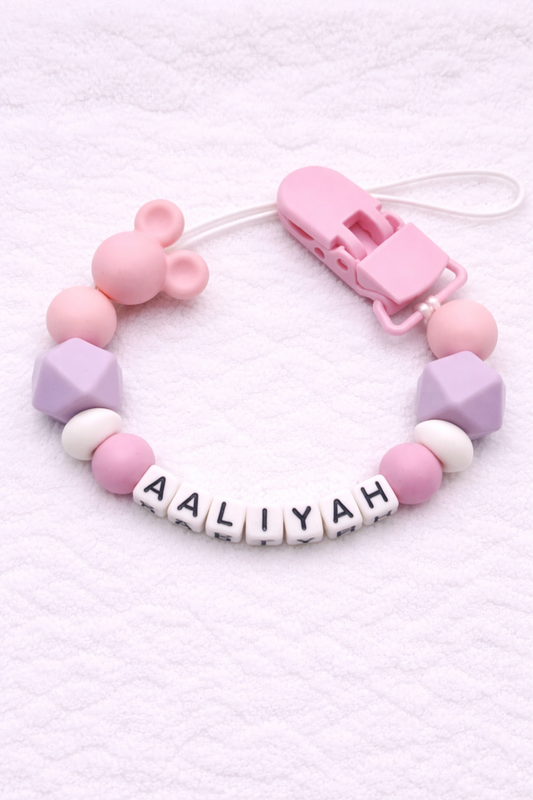 Pastel-colored dummy clip with letter beads spelling 'AALIYAH' on a white background