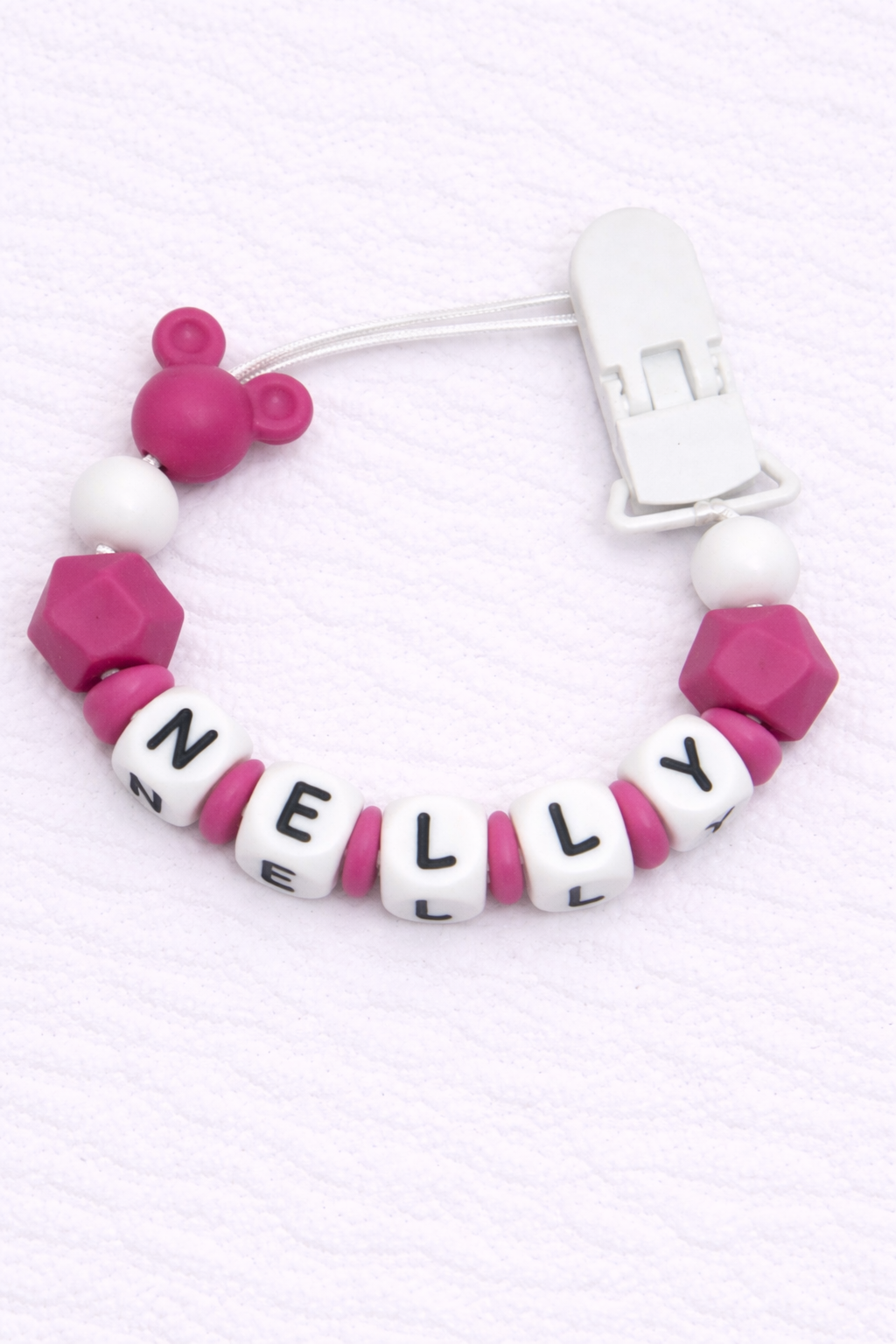 dummy clip with pink and white beads spelling 'NELLY' on a white background