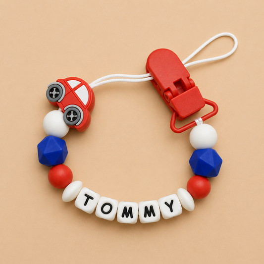 Colorful baby dummy clip with 'Tommy' name on a beige background