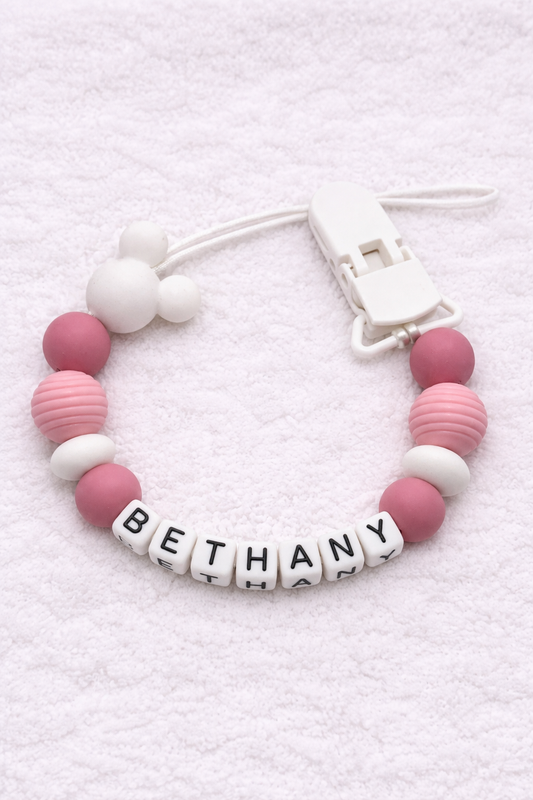 Dummy Clip with pink and white beads and a name tag on a white background