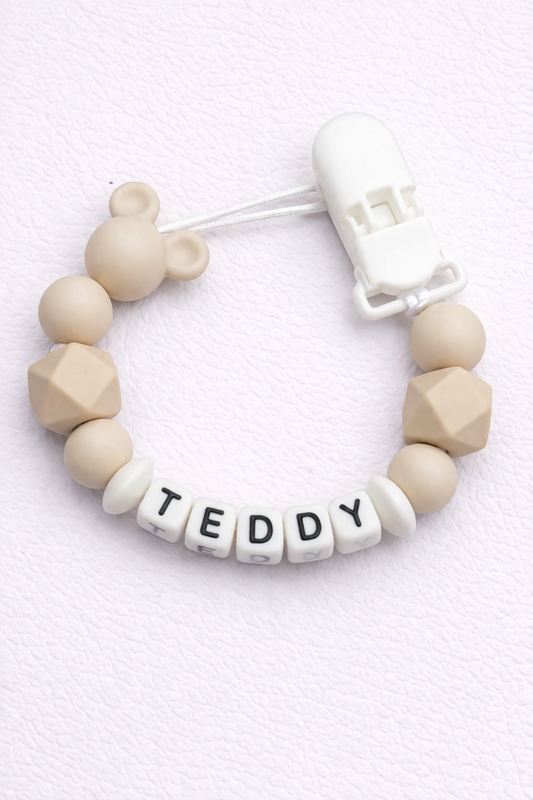 dummy clip with silicone beads and 'TEDDY' letter beads on a light background