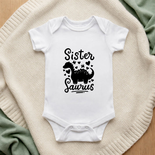 White baby onesie with 'Sister Laurus' print on a textured surface