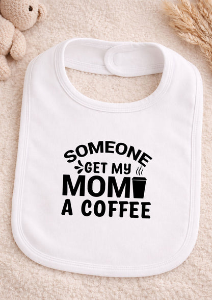 White baby bib with black text 'Someone get my mom a coffee' on a beige surface.