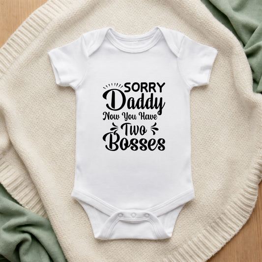 White baby onesie with text on a textured surface