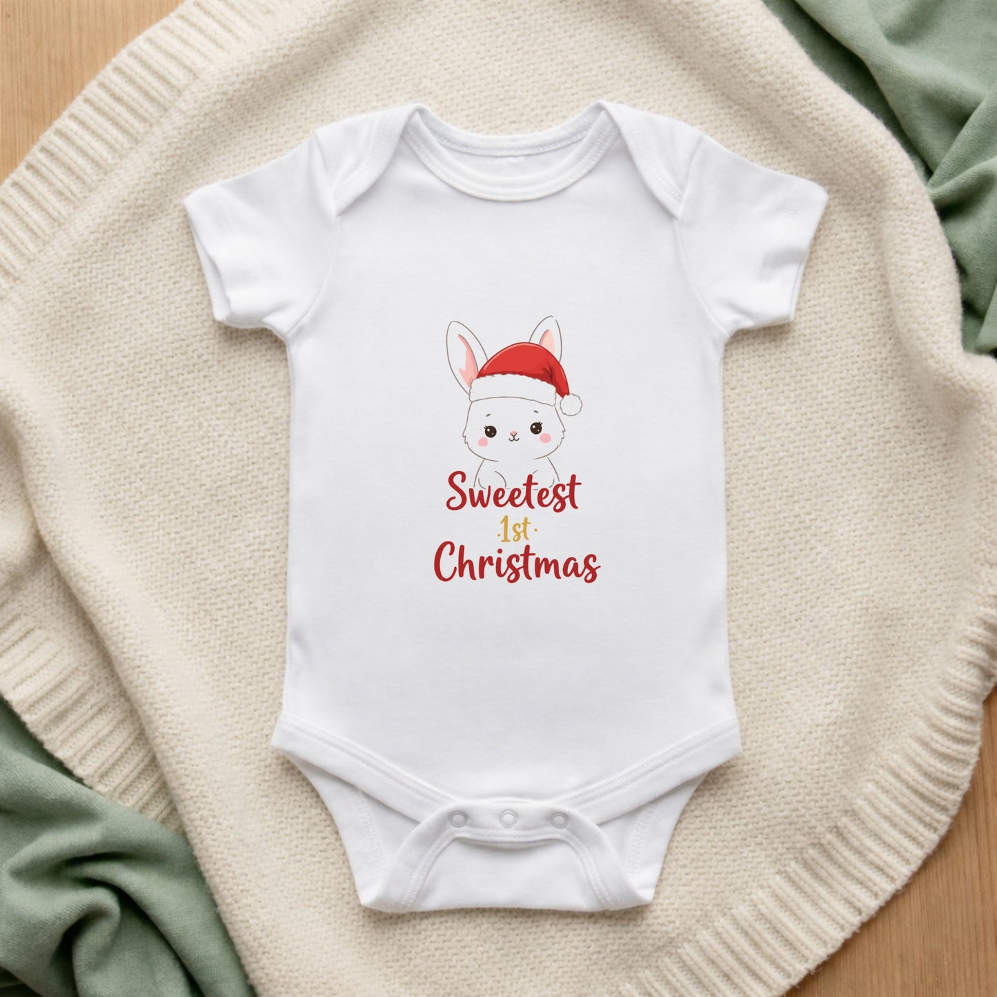 White baby onesie with a Christmas design on a textured surface