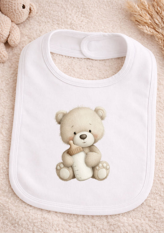 White baby bib with teddy bear design on a soft beige background