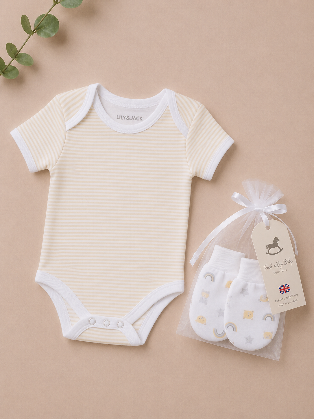 Baby onesie and booties set on a beige background