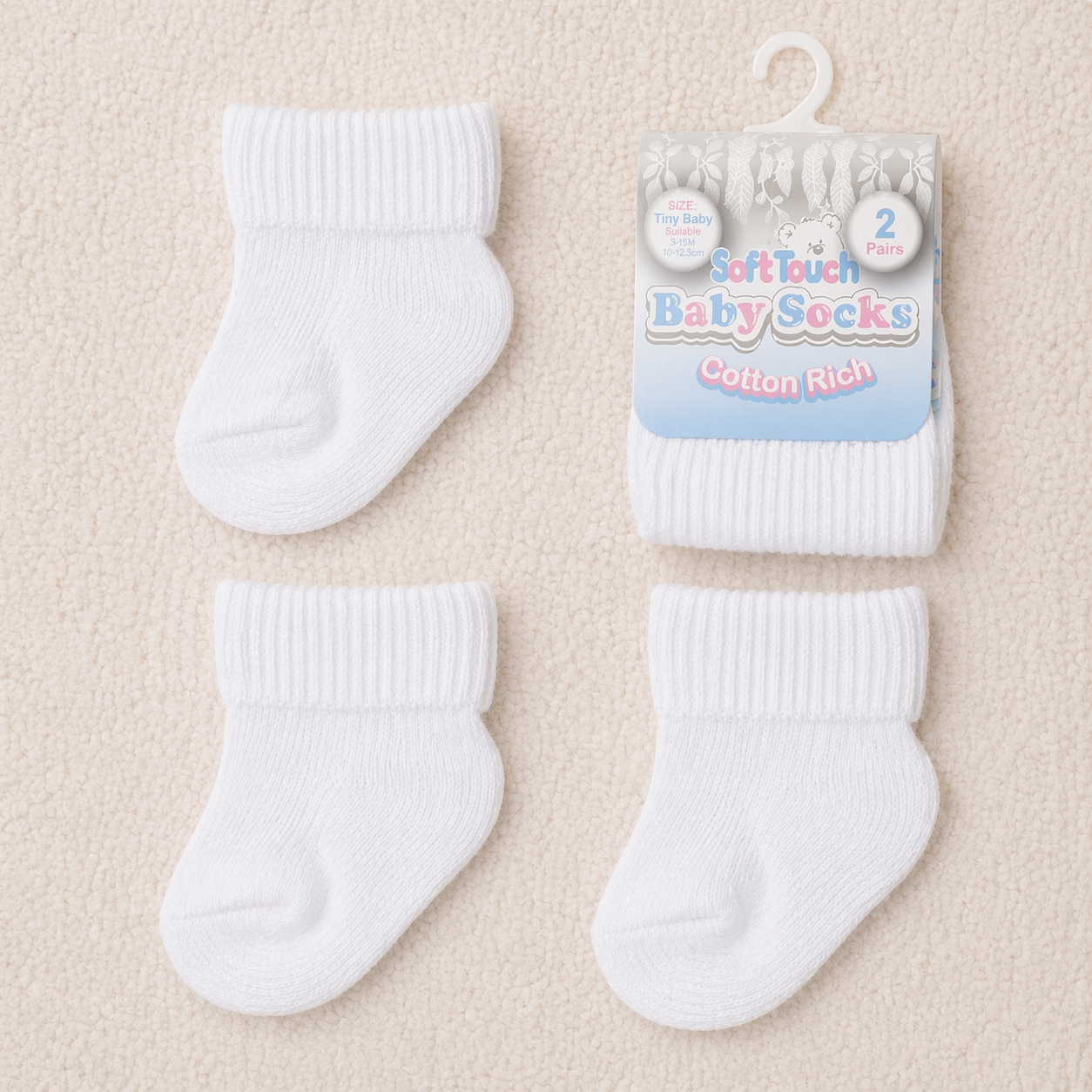 Three white baby socks with one on a hanger and two displayed flat on a beige background.