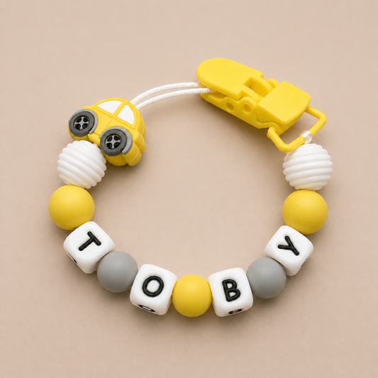 dummy clip with colorful beads and a car-shaped clip on a beige background