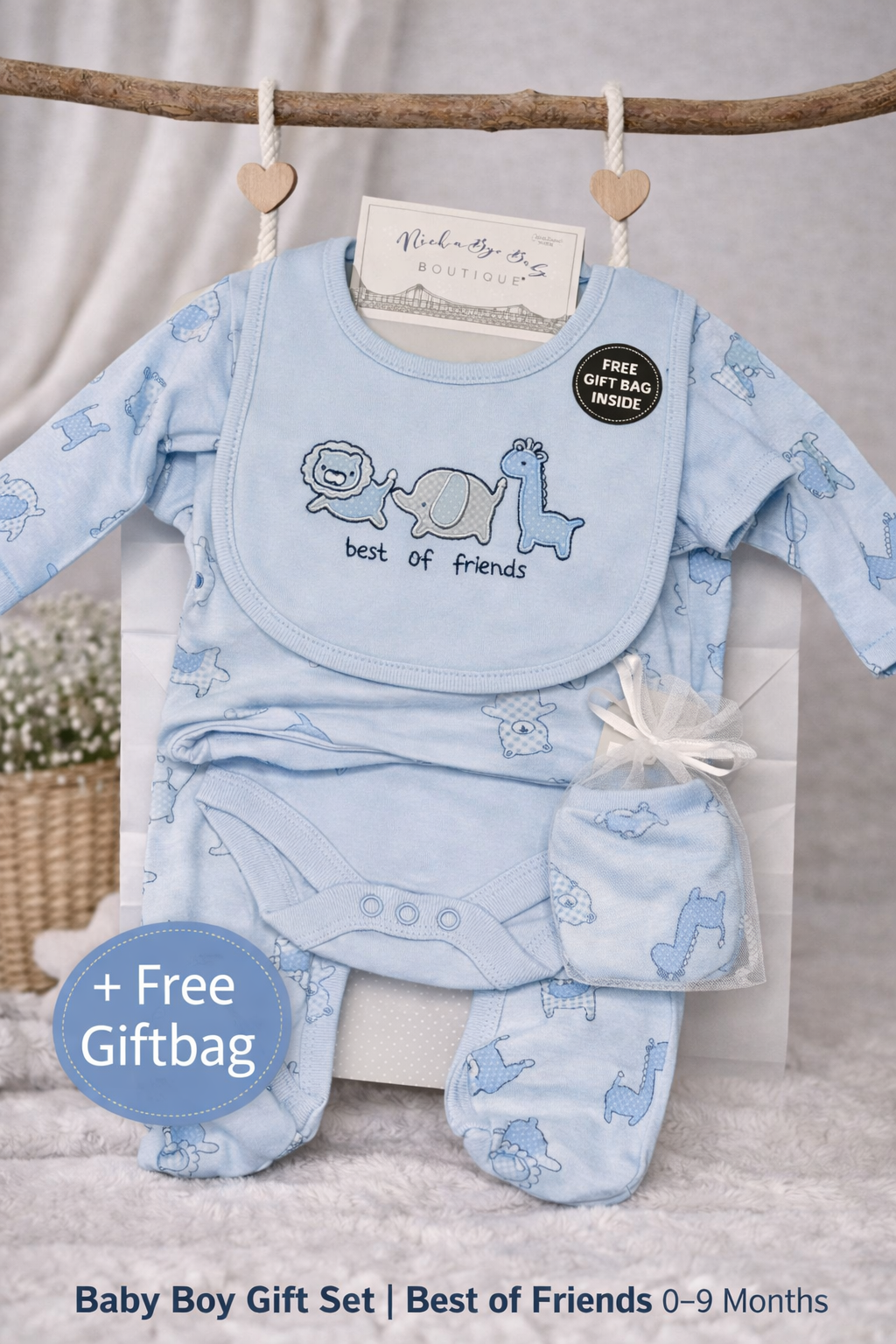 Baby boy gift set with bib, babygrow, and hat and mittens on a branch with a free giftbag offer.