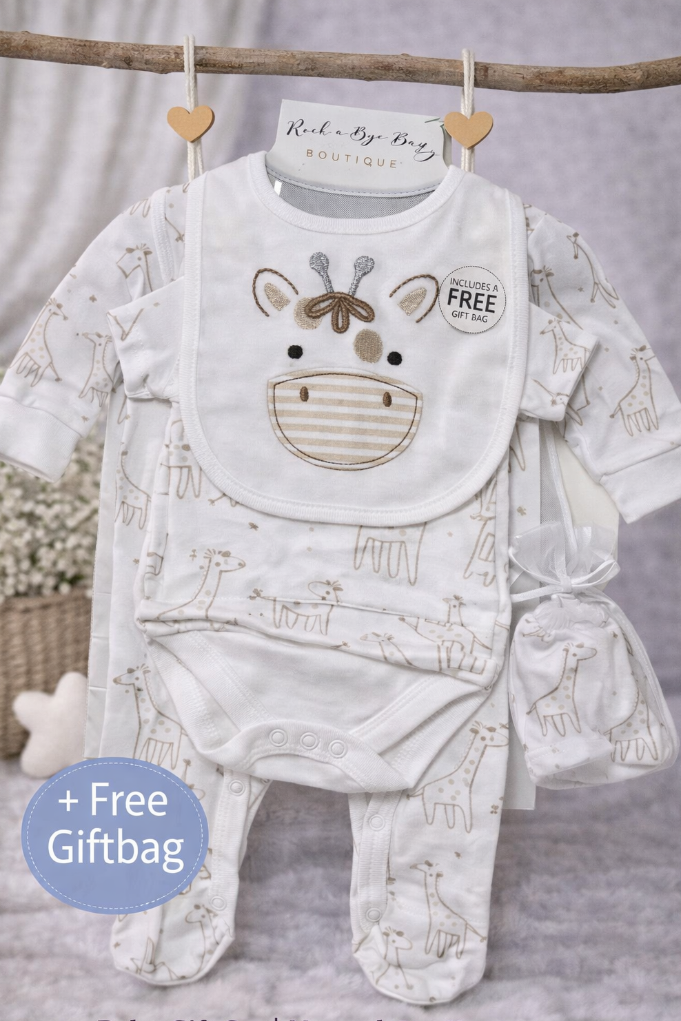 Baby gift set with neutral giraffe design on a hanger against a gray background