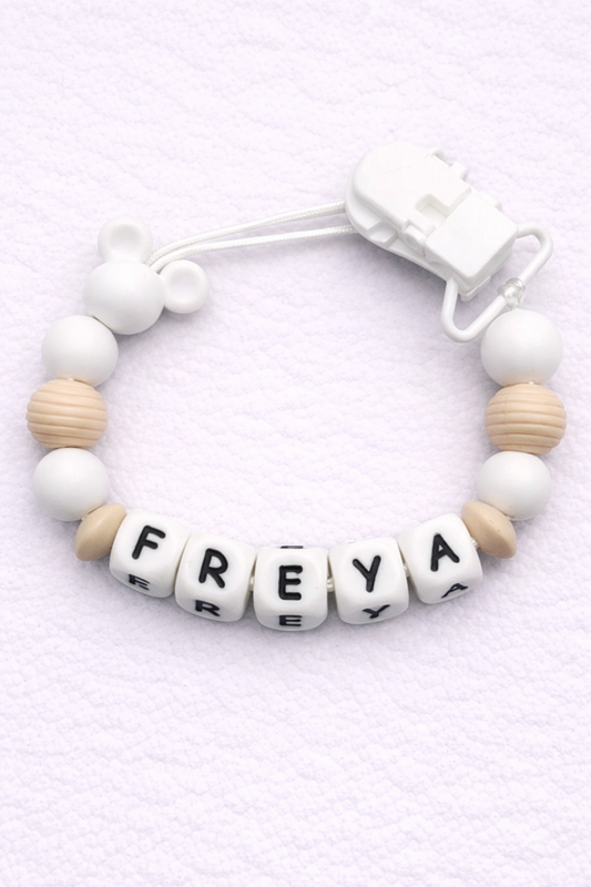 dummy clip with letter beads spelling 'FREYA' on a light purple background