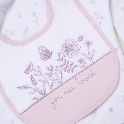 Embroidered bib with floral design and 'you are loved' text on a light background