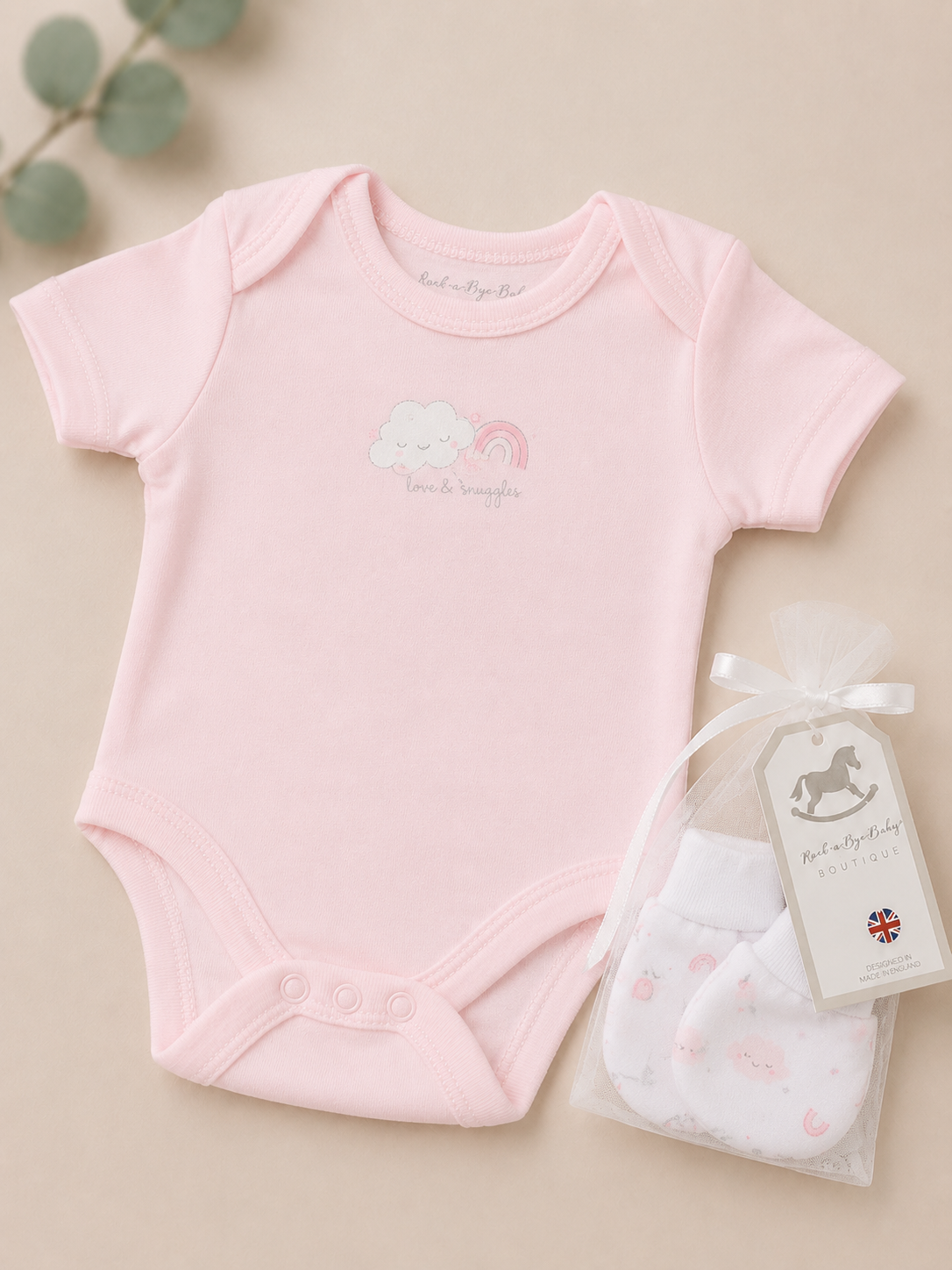 Pink baby bodysuit with a matching bib on a beige background