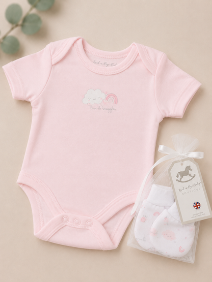 Pink baby bodysuit with a matching bib on a beige background