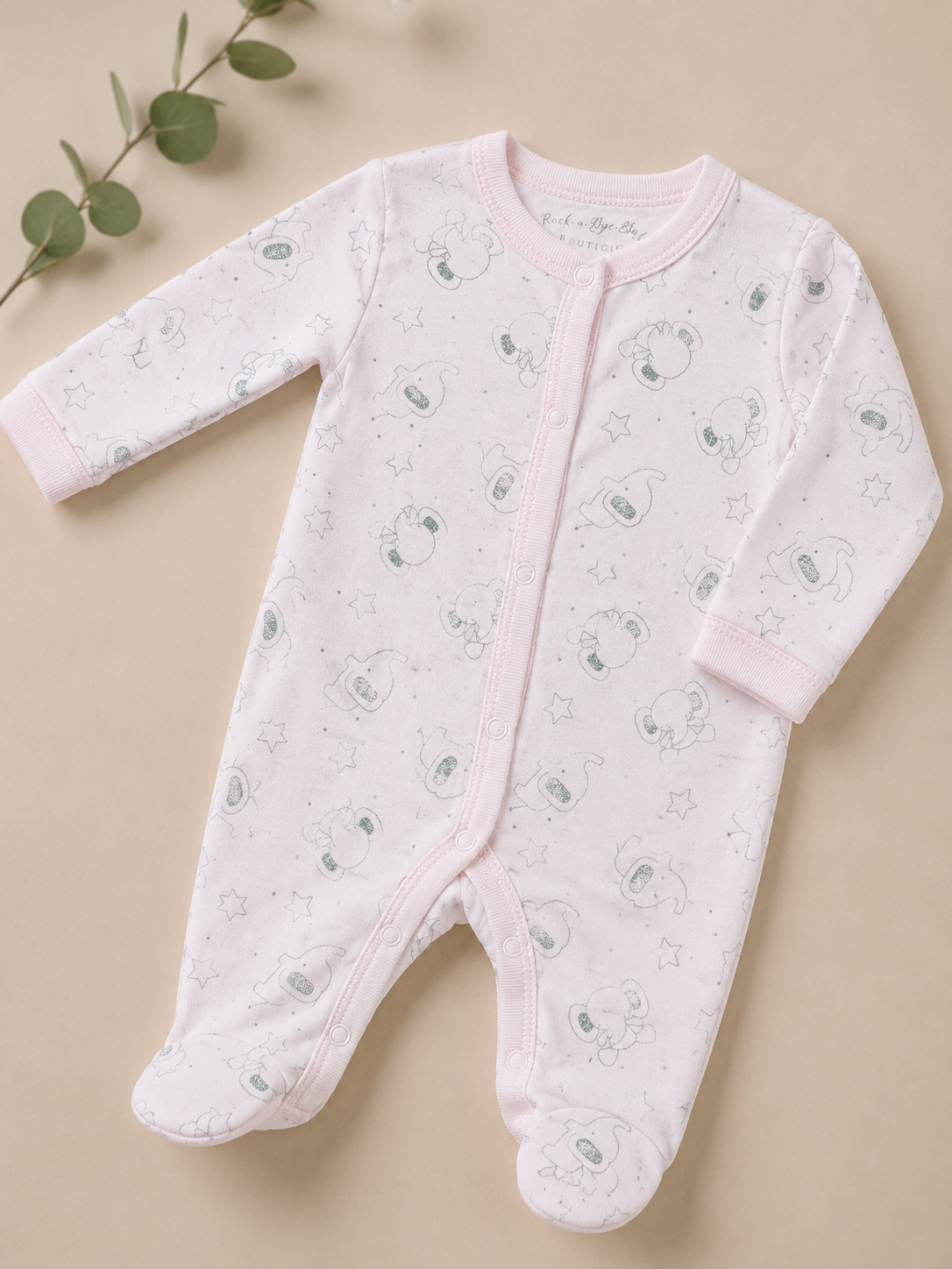 Baby onesie with animal pattern on a beige background