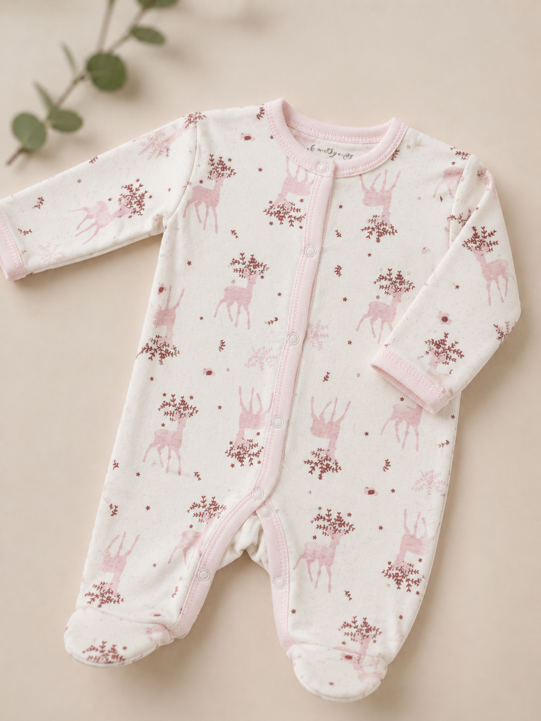 Baby onesie with deer pattern on a beige background