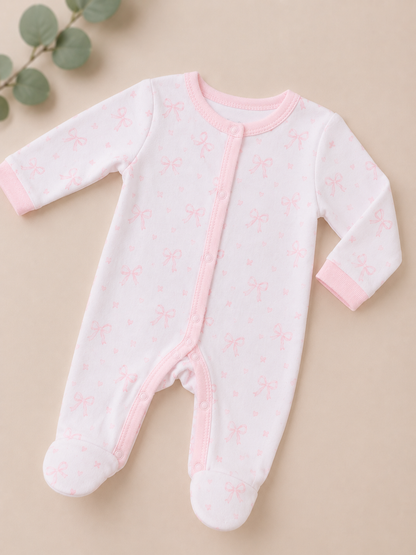 Baby onesie with pink accents on a beige background