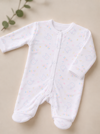 White baby onesie with colorful patterns on a beige background