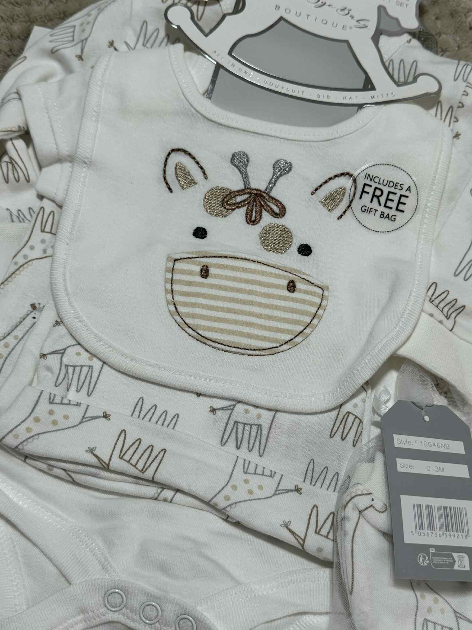 cream with giraffe print sleepsuit, bodysuit, hat, bib and mittens with giftbag