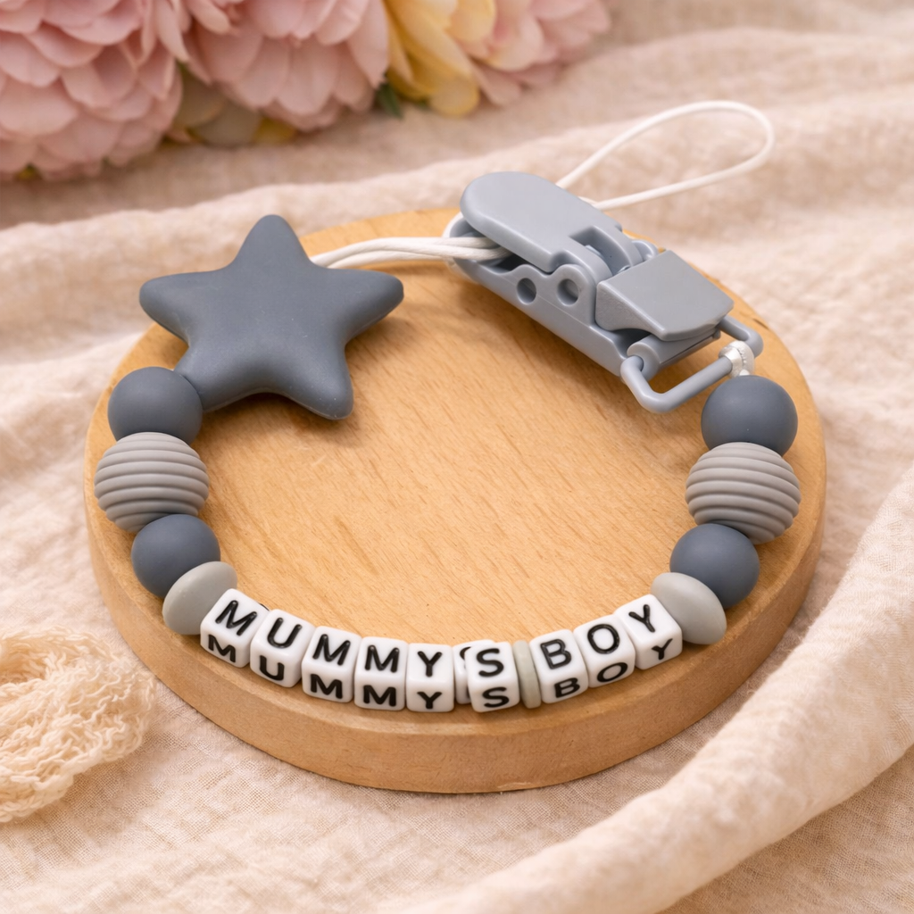 Teething ring with star-shaped bead and 'Mummy's Boy' letter beads on a wooden base.