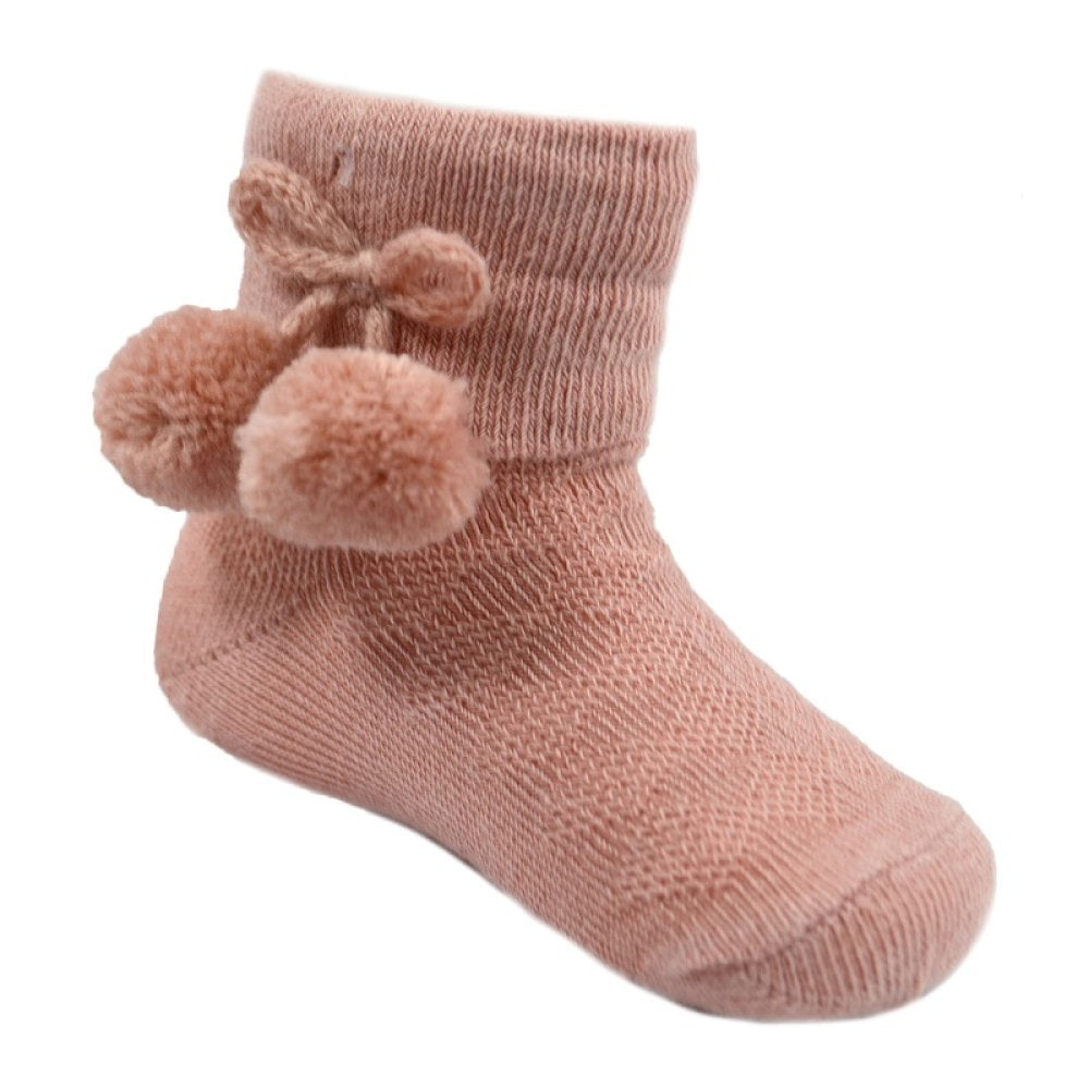 Pink baby sock with pom-poms on a white background