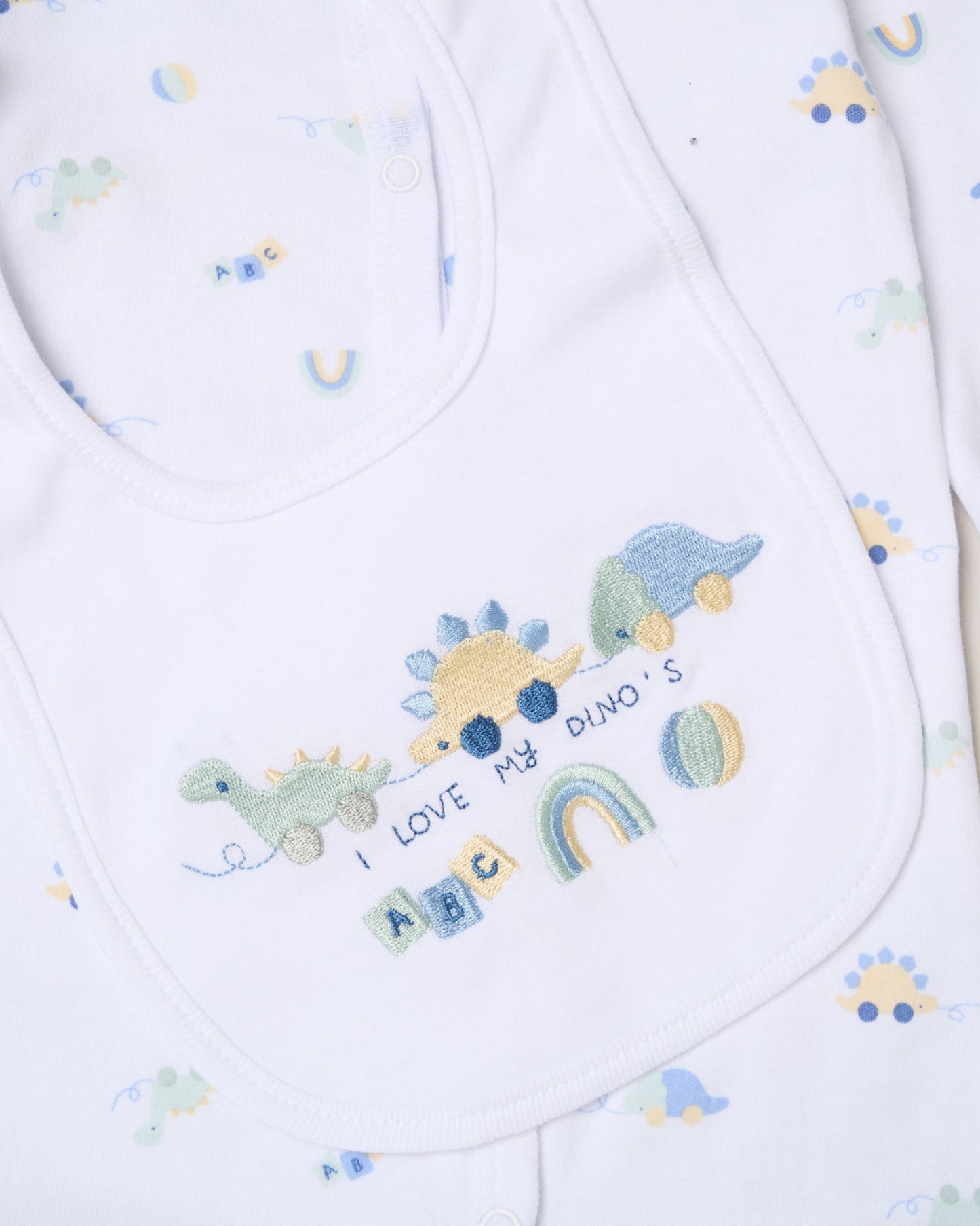 Baby bib with embroidered dinosaurs and text on a white background