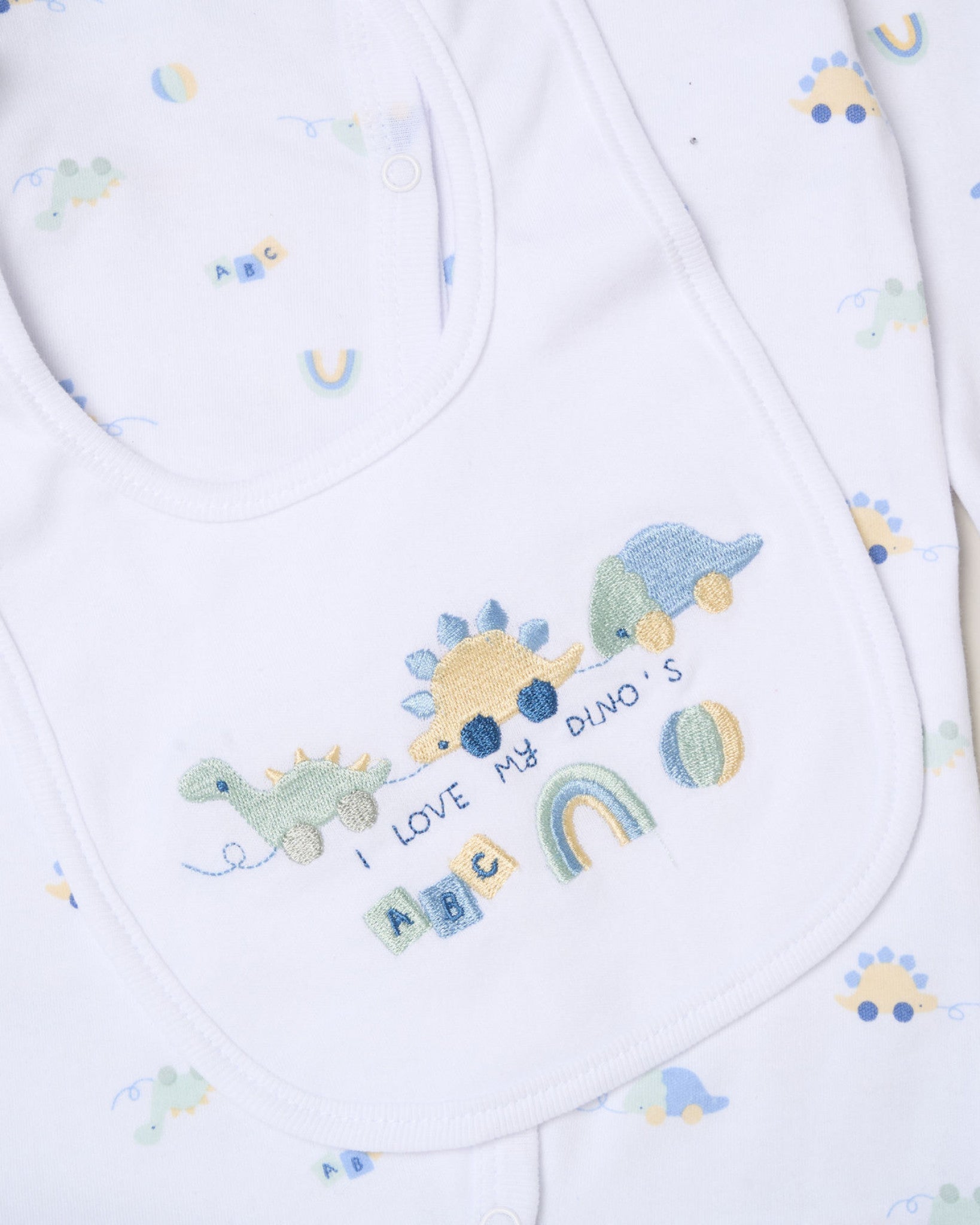 Baby bib with embroidered dinosaurs and text on a white background