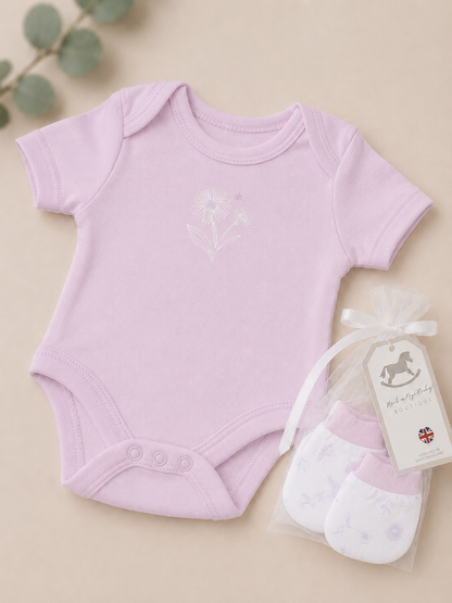 Baby onesie and socks set with a tag on a beige background