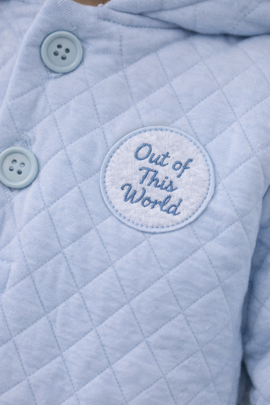 Light blue quilted jacket with 'Out of This World' patch