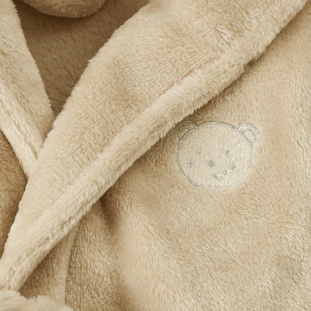 Close-up of beige plush fabric with a teddy bear design.